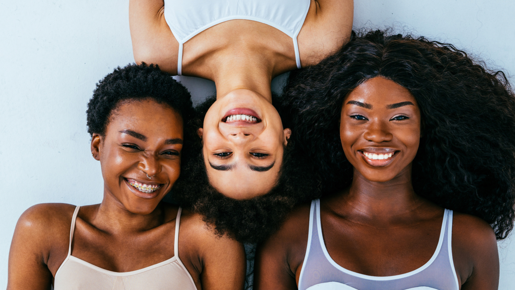 Close-up of three young women-of-colour smiling