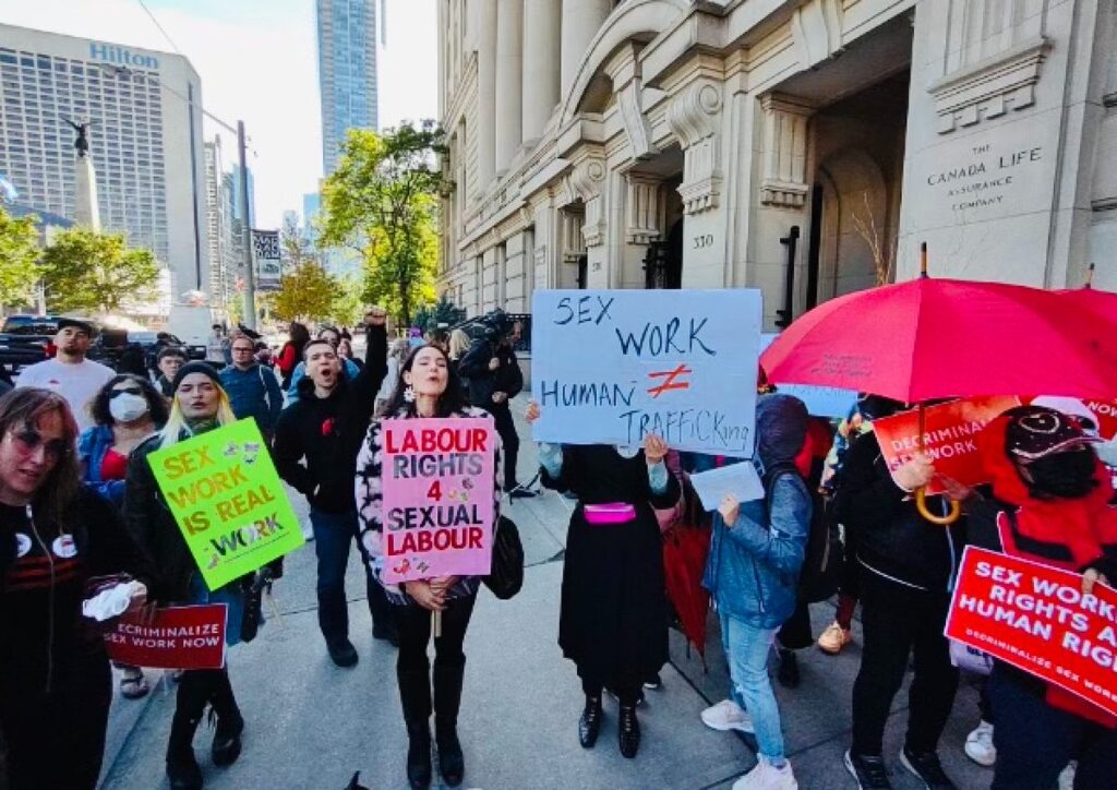 Protestors holding signs in Toronto, calling for sex-work to be decriminalized
